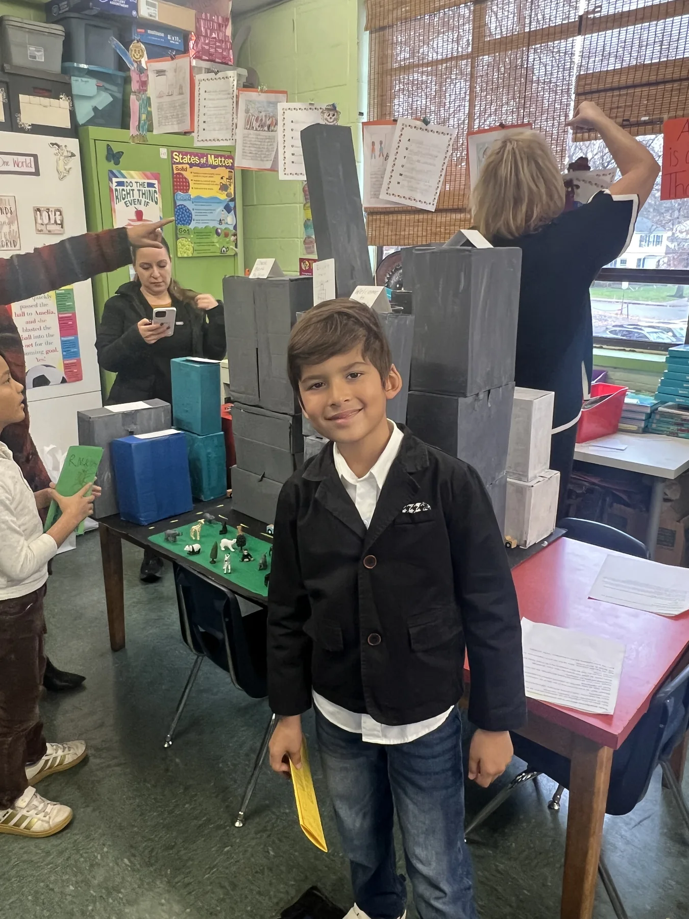 A student standing beside a detailed architectural design project
