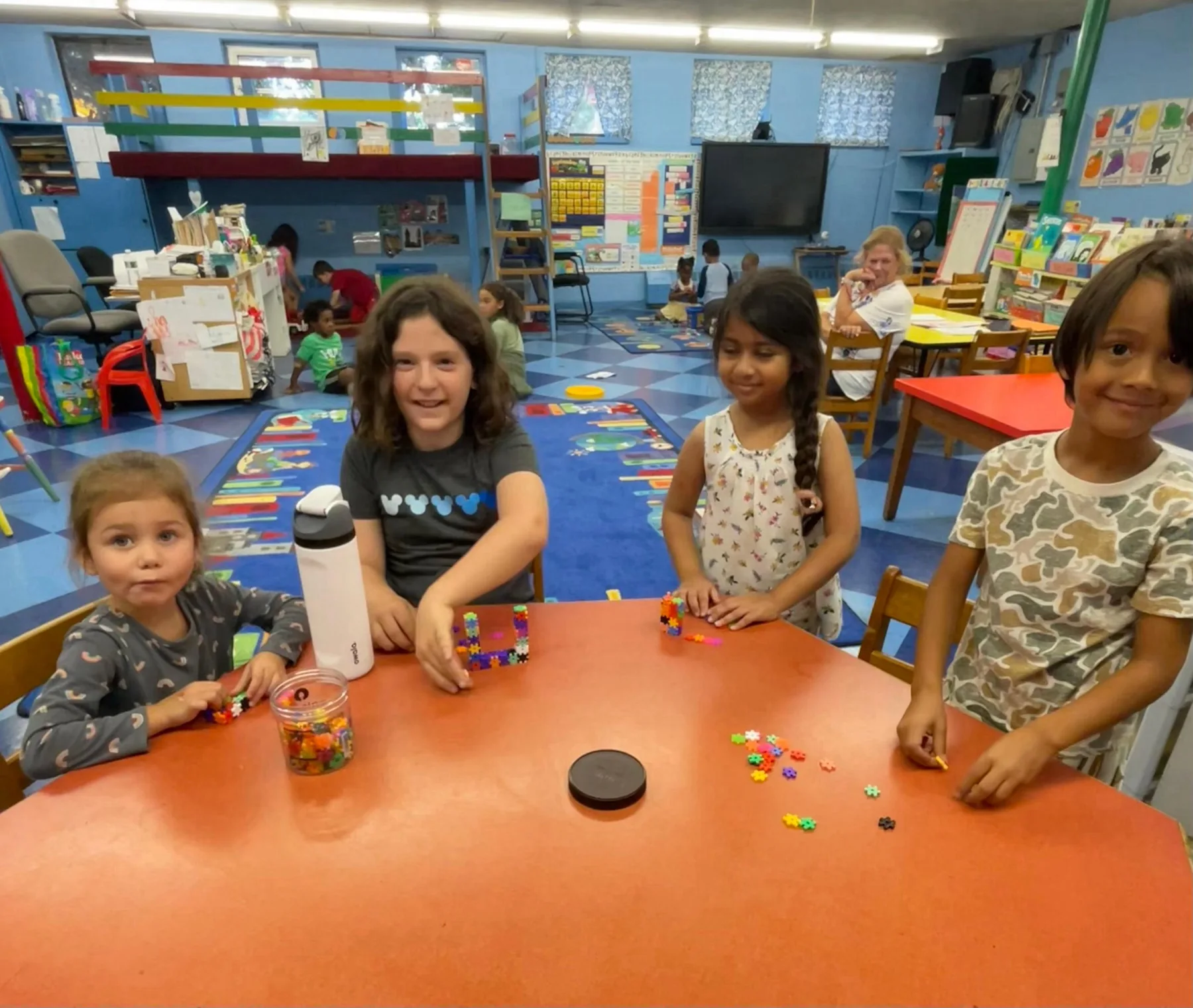 Elementary students exploring materials together at a classroom table