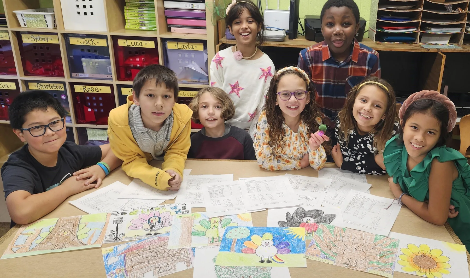 Students working together across a table covered in creative project materials
